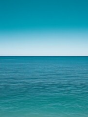 Fototapeta premium Calm ocean meeting clear blue sky.