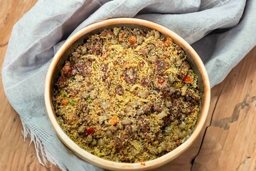 Traditional Brazilian farofa prepared with toasted cassava flour, bacon, onion and typical spices. Brazilian food