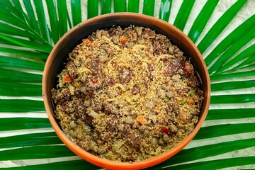Traditional Brazilian farofa prepared with toasted cassava flour, bacon, onion and typical spices. Brazilian food