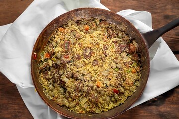Traditional Brazilian farofa prepared with toasted cassava flour, bacon, onion and typical spices. Brazilian food