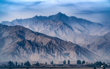 Afghanistan air pollution, Majestic mountain range under hazy sky, vast landscape.