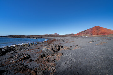 Impressive panoramic view of the black sand beach and turquoise sea on the coast of Lanzarote, Spain.