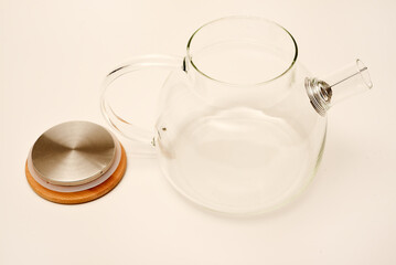 Glass teapot with wooden lid on a white background.