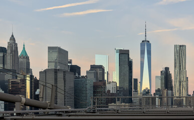 view of new york city skyline from brooklyn bridge (manhattan skyscrapers nyc) travel tourism destination landmark sunrise dawn (dark sun rising) suspension cables colorful sky beautiful photography