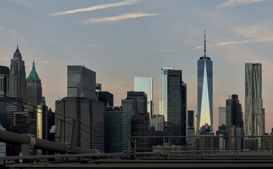 view of new york city skyline from brooklyn bridge (manhattan skyscrapers nyc) travel tourism destination landmark sunrise dawn (dark sun rising) suspension cables colorful sky beautiful photography