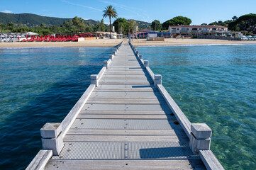 Obraz premium Morning view on crystal clear blue water of Plage du Debarquement white sandy beach near Cavalaire-sur-Mer and La Croix-Valmer, summer vacation on French Riviera, Var, France