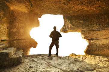 Man stand in cave mountain during sunset. Isolated object and nature. 