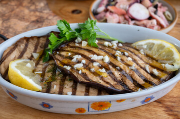 Italian style starter served in restaurant, grilled eggplant with garlic, olive oil and fresh parsley