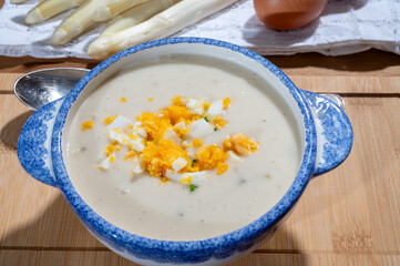 Spring season, homemade soup from raw white asparagus and cooked eggs, new harvest of Dutch, German white asparagus