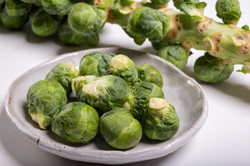 Green brussels sprouts on stalk on white table