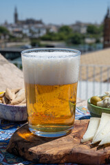 Spanish beer , cheese, tapas and green andalusian olives served on outdoor roof terrace with view on central part of old Sevilla, Andalusia, Spain