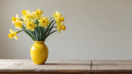 A yellow vase filled with yellow flowers on a wooden table
