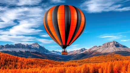 Obraz premium A vibrant hot air balloon in orange and black floats over a picturesque autumn landscape with mountains and a clear blue sky.