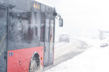 City bus on a city street during snowfall