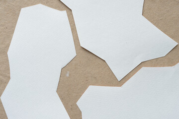 rough cut paper pieces with texture arranged on brown paper background