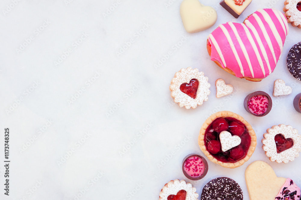 Poster valentines day baking side border with a variety of cookies, chocolates and sweets. overhead view on