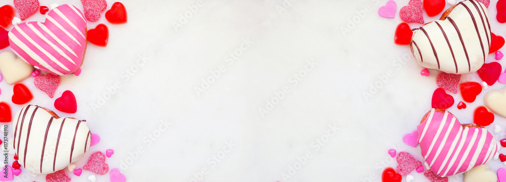 Poster valentines day heart shaped sweets double border with donuts and candies. top down view on a white m