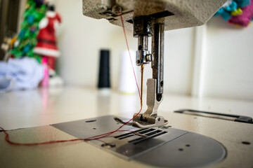 A detailed close-up of the sewing machine needle and stitch plate, capturing the precision of this essential tool for crafting, tailoring, and fashion design. This image emphasizes the intricacies of