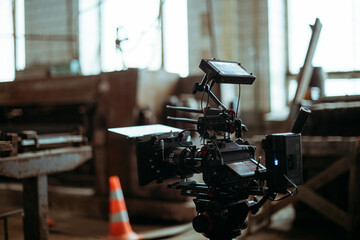 Professional cinema and video camera on the set. Shooting shift, lighting fixtures, shooting equipment and the team. Technique of modern filming and advertising.