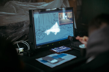 Editing director behind monitors on the set. A video editor edits video online while filming for a...