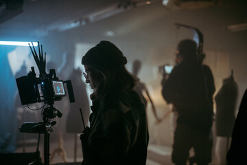 A female director at work on the set. The director works with a band or with a speaker during the...