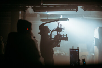 Director of photography with a camera in his hands on the set. Professional videographer at work on...