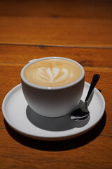 Latte art in a cozy Tallinn cafe with wooden table setting during the afternoon