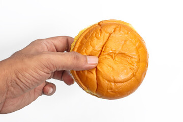 Hand holding a fresh butter bun on a white background, close-up