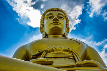 Złoty Budda na tle błękitnego nieba – majestatyczny symbol duchowości i oświecenia w Tajlandii © damian