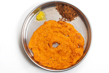 Traditional Indian dosa served with country sugar and ghee on a plate, top view