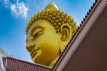 Złoty Budda na tle błękitnego nieba – majestatyczny symbol duchowości i oświecenia w Tajlandii © damian