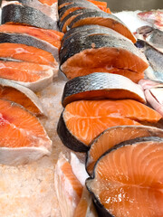 Fresh salmon fillets displayed at a bustling market during morning hours