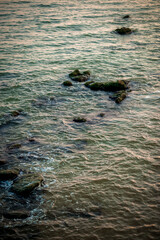 Rocks jut out into the sea, and the structure of the water is visible.
