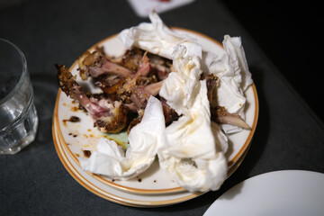 Crumpled used napkins and leftover food standing on a table in a restaurant