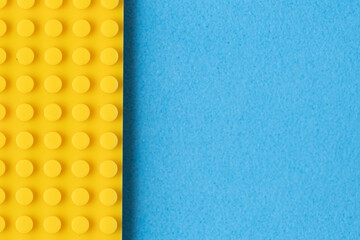 Part yellow children construction kit on blue background.