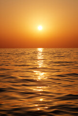 Obraz premium Golden Sunset Over Calm Ocean Waters Reflecting Sunlight