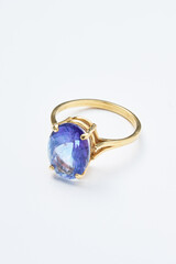 Gold Ring with Large Blue Gemstone Displayed on White Background