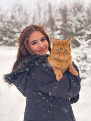 Beautiful young woman with her cat outdoors