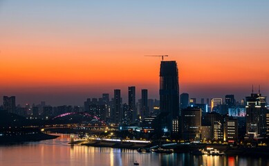 Fototapeta premium City skyline at sunset with vibrant orange sky.