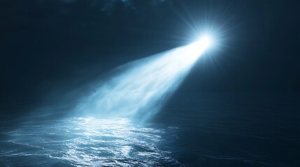 A beam of light pierces the dark ocean, illuminating the water's surface.