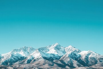 Obraz premium Majestic Snow-Capped Mountains Against Bright Blue Sky in Winter