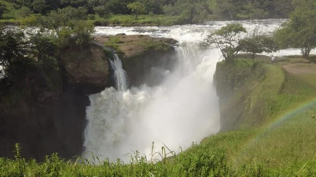 Majestic Murchison Falls in Uganda with a rainbow coming from the spray of the Nile River.