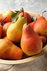 Ripe juicy pears in bowl on table, closeup
