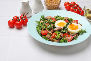 Delicious fresh tuna salad and ingredients on white tiled table