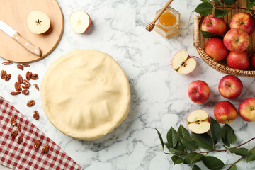 Flat lay composition with raw homemade apple pie and ingredients on white marble table