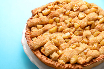 Tasty homemade apple pie on light blue background, closeup