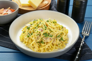 Delicious pasta Carbonara served on blue wooden table, closeup