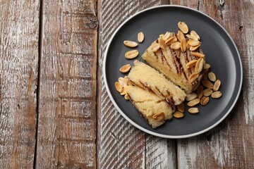 Delicious sweet semolina halva with peanuts on wooden table, top view. Space for text