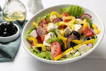 Delicious fresh Greek salad served on white table, closeup
