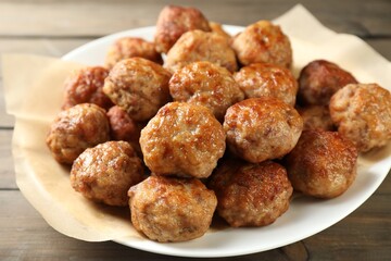 Many delicious meatballs on wooden table, closeup